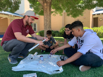 Teacher working outdoors with three students